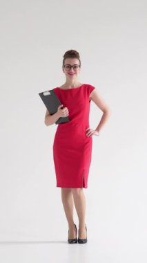 Beyaz arka planda bir portredeki olumlu ve iyimser iş kadını, profesyonel bireysellik ve basitliği kendinden emin bir ifadeyle sergiliyor. Dikey video.