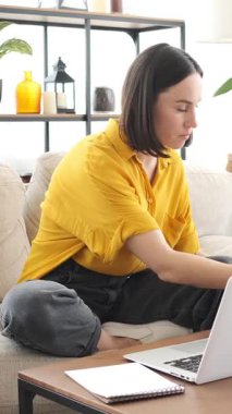 İnternette çalışan ya da evde dizüstü bilgisayarla e-öğrenmeye katılan, eğitim ve istihdama özveriyle odaklanan bir kadın. Dikey video.