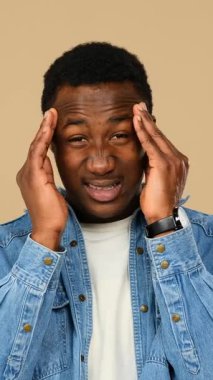 Yetişkin adam bej arka plan yüzünden şiddetli baş ağrısı çekiyor..