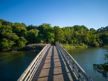 Drone view of the wooden bridge that cross country runners run over looking toward the picnic area of Sunken Meadow State Park.