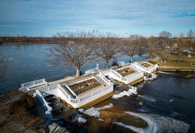 Drone view of Argyle lake and waterfalls in Babylon Long Island with ice forming due to the sun zero temperatures in February 2023.