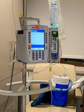 Valley Stream, New York, ABD - 17 Haziran 2022: Bir hastane odasında hasta için monitör ve serum torbasıyla tıbbi makine.