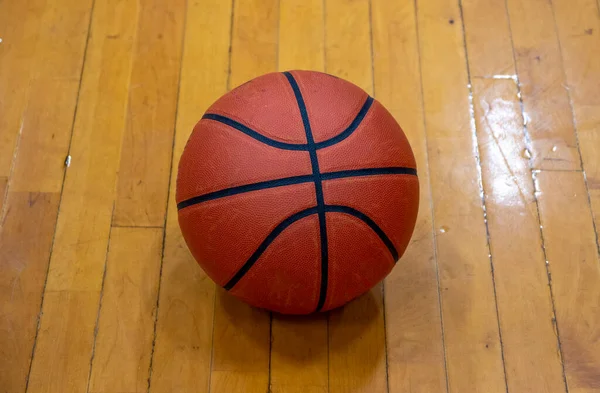 Один Оранжевый Баскетбол Черными Линиями Расположенными Полу Спортзала — стоковое фото