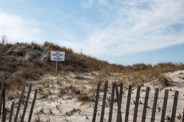 Ateş Adası 'ndaki kum tepelerindeki çitlerin arkasına asılan kum tepelerinden uzak durun..