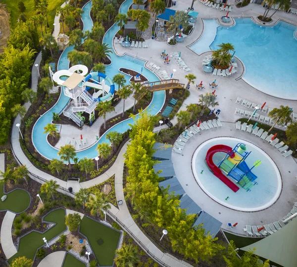 Su kayakları, tembel bir nehir, çocuklar bilardo ve yüzme havuzları olan bir tatil köyüne bakıyorum..