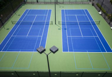 Yukarıdan mavi ve yeşil renkli Pickleball tenis kortlarının insansız hava aracı görüntüsü.