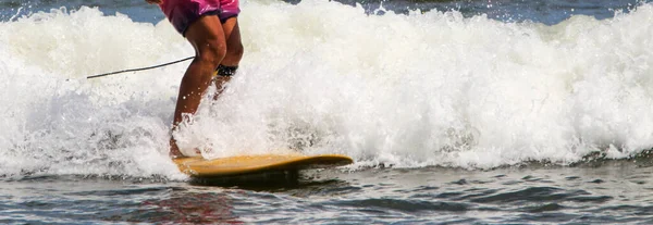 Sluiten Van Benen Van Een Surfer Een Geel Bord Aan — Stockfoto
