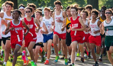 Kings Park, New York, ABD - 15 Eylül 2023: Long Island, New York 'taki Sunken Meadow State Park' ta 5K 'lık bir kros yarışının başında koşan büyük bir lise öğrencisinin ön görüntüsü.