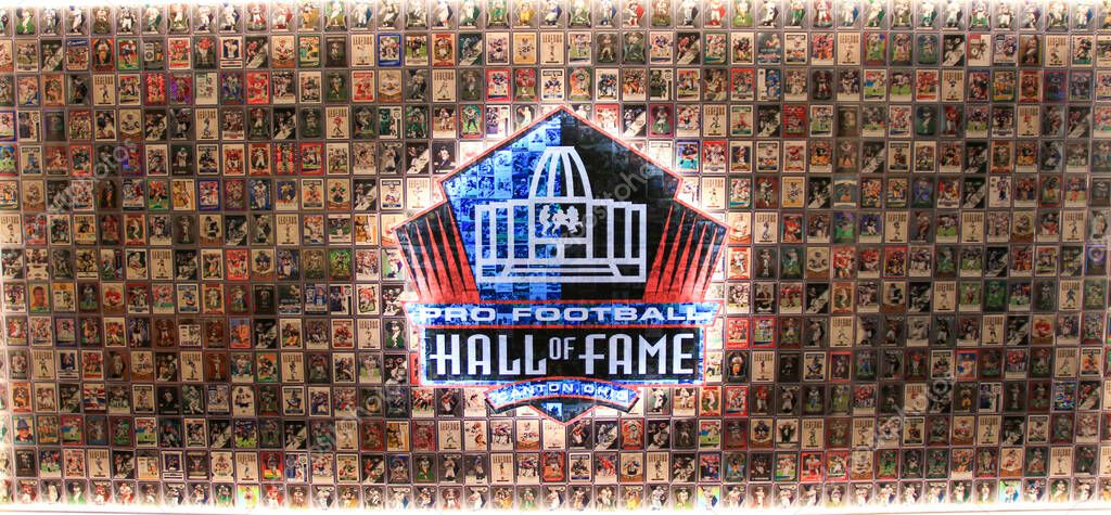 Canton, Ohio, USA - 3 August 2023: A picture of a football hall of fame logo surrounded by many football cards of the members