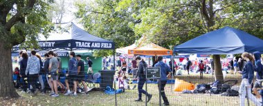 Bronx, New York, USA - 9 October 2021: A group of high school cross country runners standing around tents in Van Cortlandt park