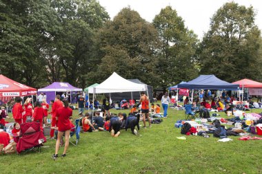 Bronx, New York, USA - 9 October 2021: A group of high school cross country runners standing around tents in Van Cortlandt park