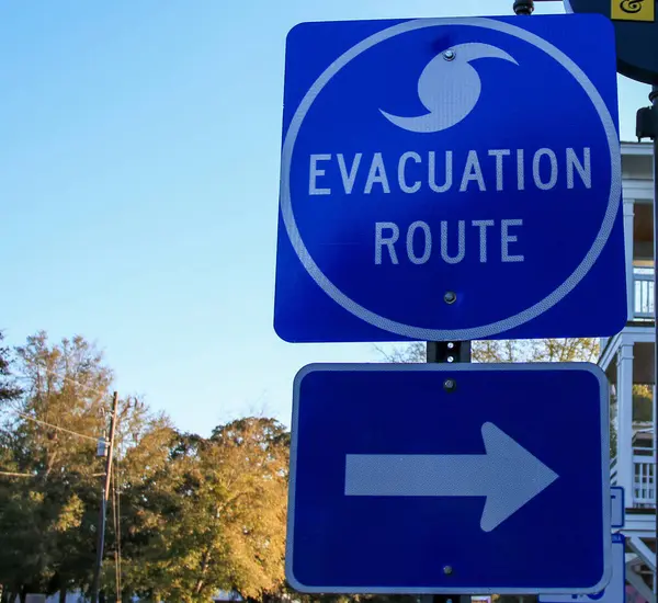 A blue street sign with white text indicating an evacuation route. The sign provides crucial information for directing people to safety in case of emergencies