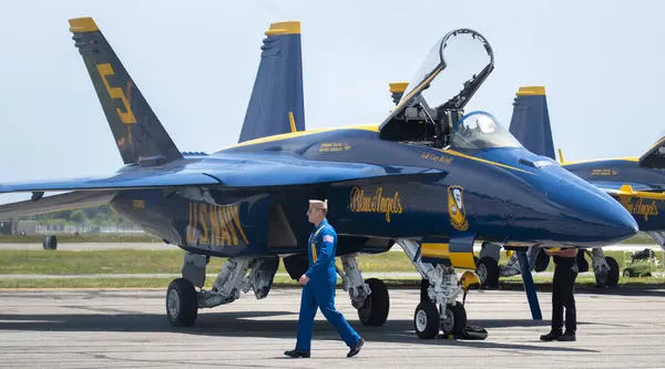 stock image Farmingdale, New York, USA - 26 May 2022: Looking at one US Navy Blue Angels Jet with its cockpit open parked at Republic airport on Long Island with the pilot walking in front.