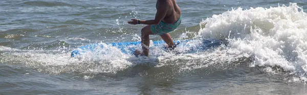 Stock image A male Surfer about to fall off his surfboard while riding a wave off the coast of Long Island.