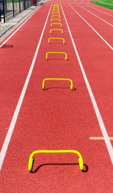 Koşu antrenmanı için kulvardaki hız antrenmanı için hazırlanan sarı küçük engellere bakıyorum..
