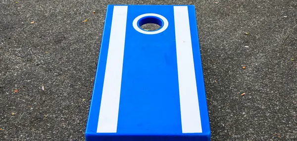 stock image Close up of a Blue and white cornhole game on a black tar street