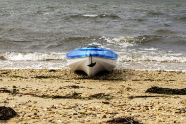 Long Island 'ın güney körfezindeki kayalık bir sahilde, suyun kenarındaki kumda oturan bir kanonun ön görüntüsü..