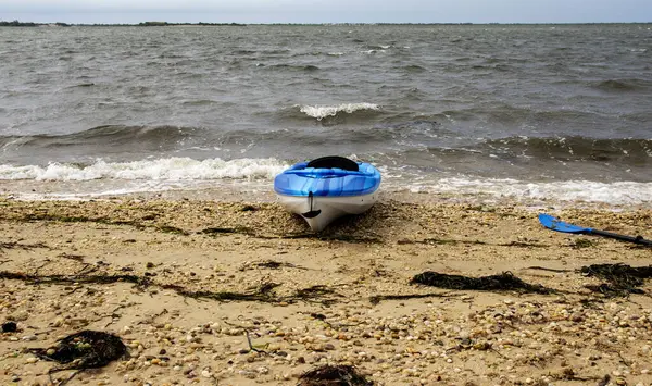 Stock image Looking at one kayak on the beach with a rough bay in the background on the Great South Bay Long Island.