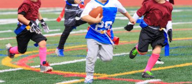 Gençler futbol maçında diğer takımı topla kovalıyorlar..