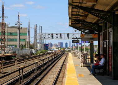 Woodside, New York, USA - 20 August 2024: Woodside Train Station Platform in Queens Looking down the tracks at New York. City. clipart