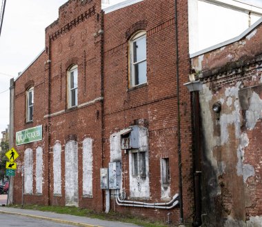 Savannah, Gürcistan, ABD - 20 Şubat 2024: Yıpranmış tuğla yapı solmuş boyalar ve şehrin caddesi boyunca klasik detaylar.