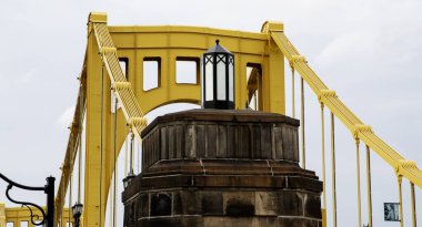 Parlak sarı köprü Pittsburgh 'un mimarisi ve tasarımı sergilenen taş bir üste dekoratif bir fener içerir..