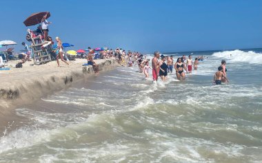 Robert Moses, New York, ABD - 4 Ağustos 2023: Sıcak bir yaz gününde plajda toplanan kalabalık güneşin, sörfün ve kumlu kıyı şeridinin tadını çıkarıyor.