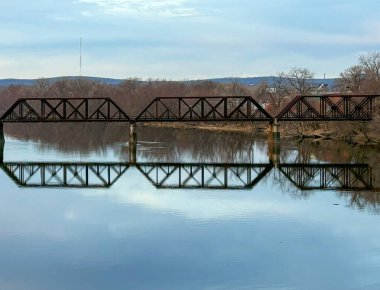 Springfield Massachusetts 'te sakin bir nehrin üzerinde durgun bir sabah sularında mükemmel bir yansıması olan bir köprü duruyor..
