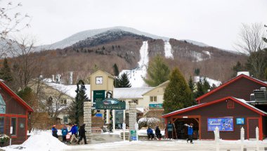 Jeffersonville, Vermont, USA - 2 January 2025: Visitors arrive at a winter recreation area featuring snow-covered mountains and skiing facilities. clipart