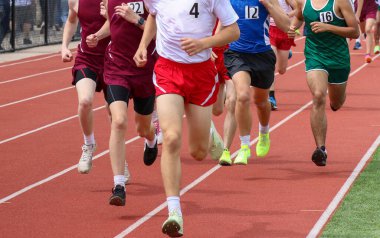Genç sporcuların yarış pistinde birbirlerine karşı yarışıp rekabetçi bir yarışmada hızlarını ve kararlılıklarını sergiledikleri ön manzara..