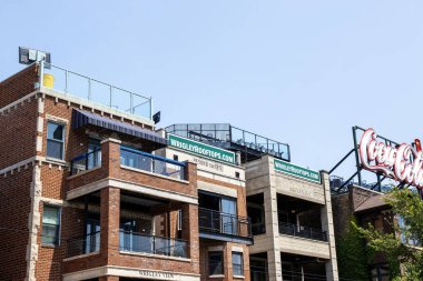 Chicago, Illinois, ABD - 19 Temmuz 2024: İnsanlar Chicago, Illinois 'de güneşli bir günde Wrigley Field' a bakan çatı manzarasının keyfini çıkarıyorlar.