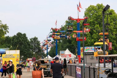 Columbus, Ohio, ABD - 5 Ağustos 2023: Festivale katılanlar renkli kabinler ve Ohio Eyalet Fuarı 'nın tepesinde yükselen gökyüzü turu ile dolu patikalarda geziniyorlar.