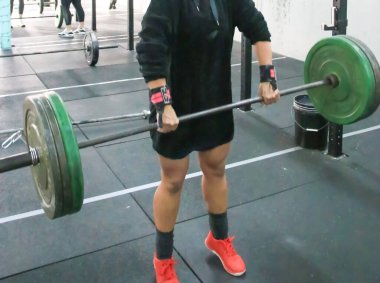 Spor salonunda ağırlık kaldıran bir adam spor yaparken ağırlık kaldırır..