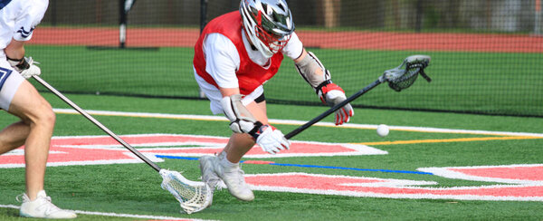 Exciting action as two lacrosse players strive for control of the ball during practice.