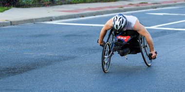 Güneşli bir günde, şehir sokaklarında maraton boyunca el bisikleti süren katılımcı yarışlar.