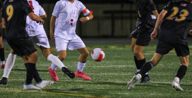 Genç sporcular bir akşam futbol maçı sırasında sahada şiddetli bir rekabet içindeler..