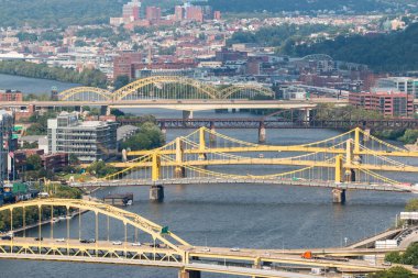 Pittsburgh, Pennsylvania, ABD - 8 Ağustos 2023: Pittsburgh Sarı köprüler nehri geçiyor, kentsel alanları birbirine bağlıyor ve ufuk çizgisini gözler önüne seriyor.