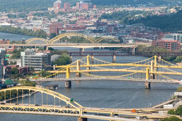 Pittsburgh Sarı köprüler nehri geçiyor, şehirleri birbirine bağlıyor ve gökyüzünü gösteriyor.