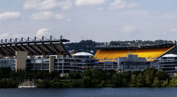 Pittsburgh, Pennsylvania, ABD - 8 Ağustos 2023: Nehir kenarındaki futbol stadyumu parlak sarı koltuklar ve güneşli bir atmosfere sahiptir..