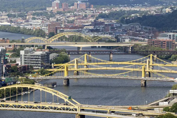 Pittsburgh, Pennsylvania, ABD - 8 Ağustos 2023: Pittsburgh Sarı köprüler nehri geçiyor, kentsel alanları birbirine bağlıyor ve ufuk çizgisini gözler önüne seriyor.
