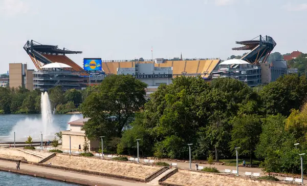 Pittsburgh, Pennsylvania, ABD - 8 Ağustos 2023: Pittsburgh Futbol Stadyumu, güneşli bir günde deniz manzarasını yansıtan yeşilliklerle çevrili.