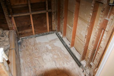 İnşaat çalışmaları tamamlanmayı bekleyen bir odada çıplak duvarları ve zemini gösteriyor..