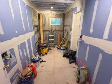 Babil, New York, ABD - 8 Haziran 2025: Alet ve malzemelerin etrafa saçıldığı küçük bir odada inşaat çalışmaları sürüyor.