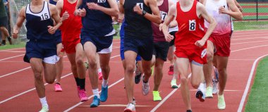 Çocuklar canlı atletizm formaları ve kararlılıklarıyla bir pistte yarışıyorlar..