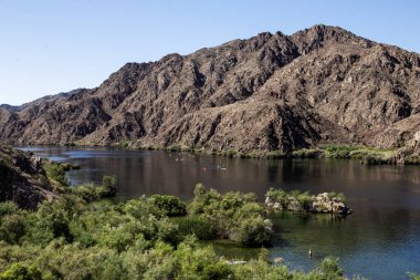 Kanocular Arizona 'daki dağlarla çevrili sakin sularda kürek çekerler..