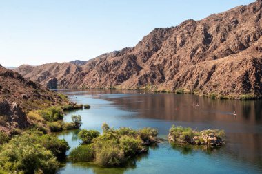 Sakin sular engebeli dağların arasından akar yemyeşil kıyılar boyunca..