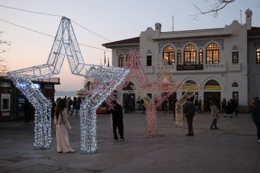 İstanbul, Türkiye - 20 Aralık 2023: Kadıköy İstanbul 'da insanlar eğleniyor ve büyük ışıklandırılmış Noel süsleriyle fotoğraf çekiyor.