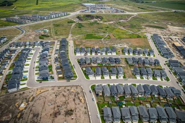 Saskatoon 'daki Rosewood mahallesinin yükseltilmiş görüntüsü, Saskatchewans' ın sakin doğal tuvaliyle iç içe geçmiş kentsel tasarım bir duvar halısı sunuyor..