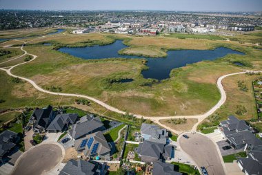 Saskatoon 'daki Rosewood mahallesinin yükseltilmiş görüntüsü, Saskatchewans' ın sakin doğal tuvaliyle iç içe geçmiş kentsel tasarım bir duvar halısı sunuyor..