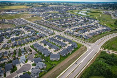 Saskatoon 'daki Rosewood mahallesinin yükseltilmiş görüntüsü, Saskatchewans' ın sakin doğal tuvaliyle iç içe geçmiş kentsel tasarım bir duvar halısı sunuyor..